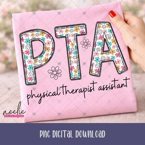 May include: A light pink t-shirt featuring the letters PTA in a floral pattern with pink, yellow, and teal flowers. Below the letters, the text physical therapist assistant is printed in black script. A small flower outline is also visible.