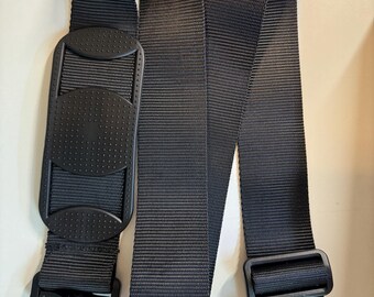 May include: Black adjustable camera strap with a padded shoulder rest and a metal hook on each end.