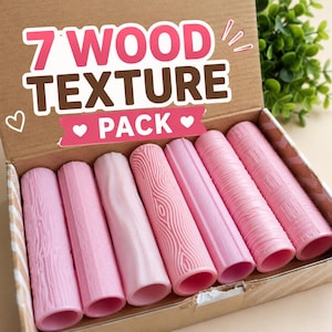 May include: A cardboard box containing seven cylindrical pink rollers, each featuring a distinct embossed wood grain texture. The box lid displays the text 7 WOOD TEXTURE PACK in large pink and brown letters, accompanied by small white heart icons.