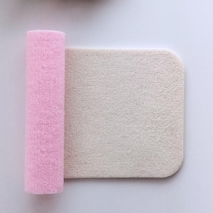 Könnte beinhalten: Eine rosa und weiße Stoffmatte, die aufgerollt ist. Die Matte besteht aus einem weichen, strukturierten Stoff.