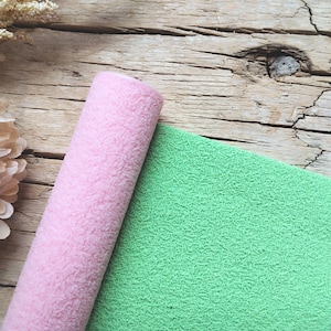 以下が含まれることがあります： ピンクとグリーンのテクスチャのある生地のロール。生地は柔らかくふわふわで、クラフトやデコレーションに最適です。
