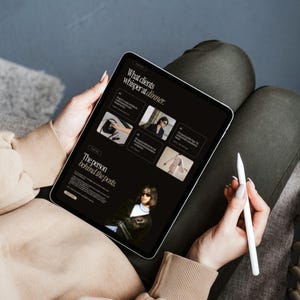May include: A tablet displaying a dark-themed website with the text What clients whisper at dinner and The person behind the posts. The screen features multiple image thumbnails and a white stylus is held in the hand next to the device.