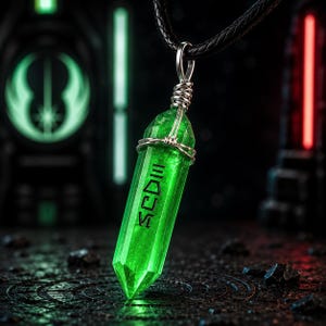 Könnte beinhalten: Ein grüner Kristallanhänger mit silbernem Draht und schwarzem Band. Der Kristall hat gravierten Text und ein facettiertes Design. Der dunkle Hintergrund ist mit grünen und roten Lichtern beleuchtet, was ein Sci-Fi- oder Fantasy-Thema suggeriert.