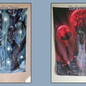 Puede incluir: Dos tapices de tela. El primero presenta una escena invernal con un &aacute;rbol, una criatura y el texto "SnowGlobe Tree". El segundo representa una figura de tipo drag&oacute;n con tres lunas rojas y el texto "Darkstalker".