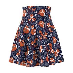 May include: A flared skirt with a repeating pattern of orange foxes, white holly leaves, and red berries on a navy blue background. The skirt has a high waist and a full, flowing shape, suitable for various occasions.