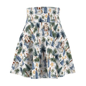 May include: A high-waisted skater skirt featuring a repeating pattern of a nativity scene. The print includes figures in blue robes, small stone buildings, green palm trees, and yellow stars against a white background. The skirt has a flared silhouette.