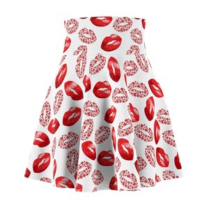 Op de afbeelding: Een witte skaterrok met een all-over print van rode lippen. Sommige lippen zijn effen rood, terwijl andere zijn samengesteld uit kleine rode bladpatronen. De rok heeft een hoge taille en een uitlopend silhouet dat boven de knie valt.