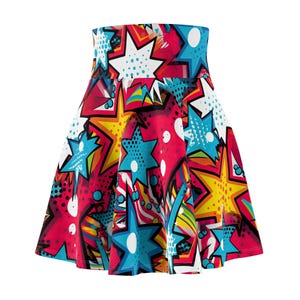 Puede incluir: Una falda skater de talle alto con un vibrante estampado pop art de estrellas multicolores en tonos azul, amarillo y blanco sobre un fondo rosa y rojo brillante, acentuado con puntos de trama negros y elementos gráficos estilo cómic.