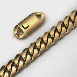 May include: Gold-coloured chain link necklace with a matching clasp. The necklace features a thick, rounded curb chain design. The clasp is a rectangular shape with a curved top and a square opening. The chain and clasp are on a white background.