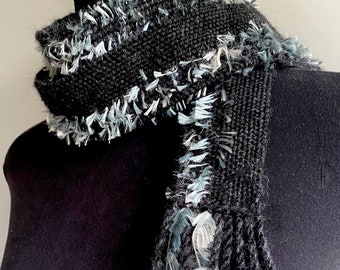 Charcoal and black skinny scarf. Alpaca, silk, merino, with a thin line of slate/silver-blue polyester feathers. Very soft. Elegant.