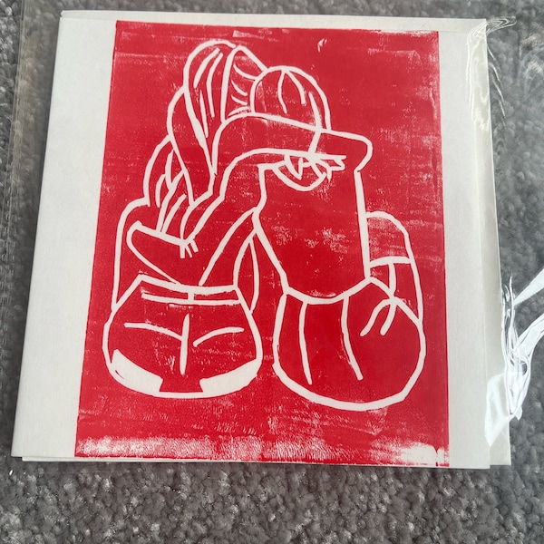 Lino print of two sisters hugging. In red.