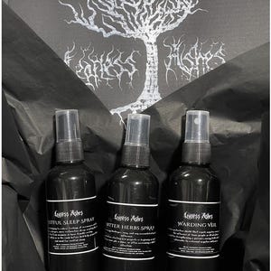 May include: Three black spray bottles with white labels and black text. The bottles are labeled "Restful Sleep Spray", "Bitter Herbs Spray", and "Warding Veil".