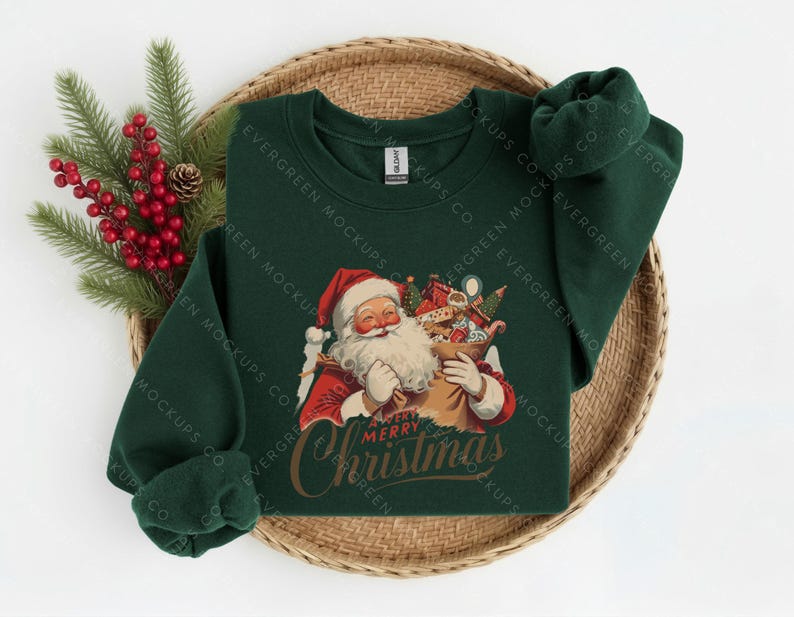 May include: A dark green long-sleeved sweatshirt featuring a graphic of Santa Claus holding a sack filled with gifts. Below the illustration, the text reads A VERY MERRY Christmas in a stylised script font. The garment has a crew neckline.