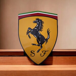 May include: A yellow shield with a black rearing horse and the letters "SF" in the center. The shield has a red and green stripe at the top.