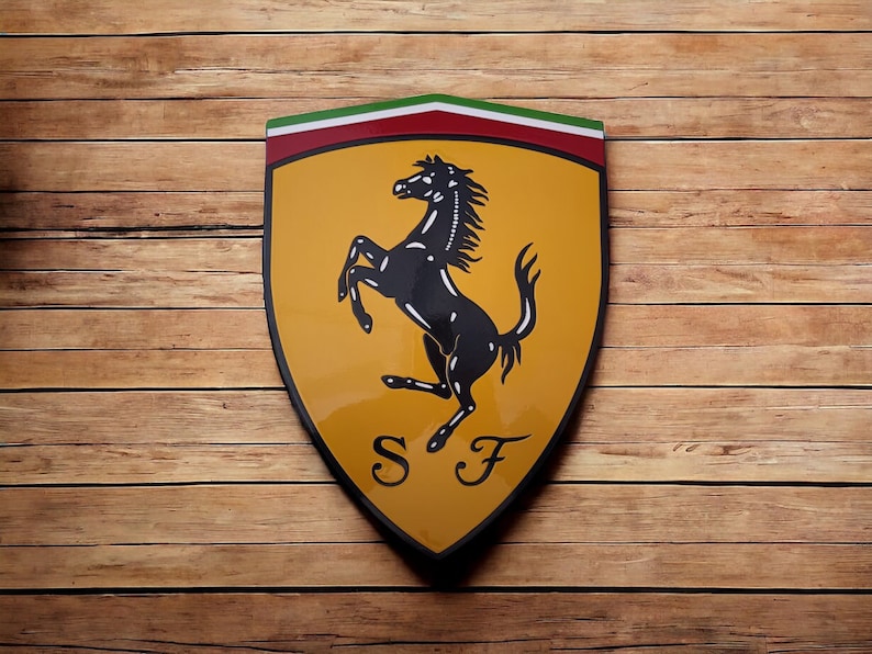 May include: A yellow shield-shaped logo with a black rearing horse and the letters "SF" in the center. The shield has a red and green stripe at the top.