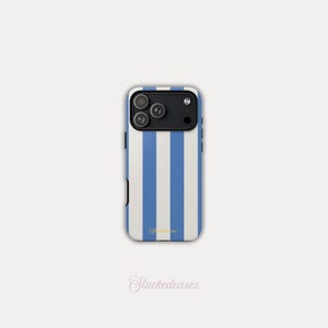 May include: A smartphone case with a vertical blue and white striped pattern. The case has a black camera module and the brand name "Stackedeases" is written in cursive at the bottom.