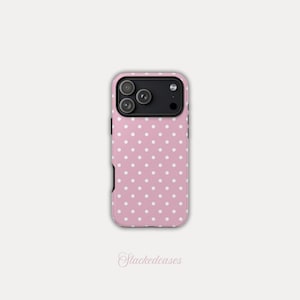 May include: A pink phone case with a white polka dot pattern. The case has a black camera module and black edges. The text "Stackedeases" is written in cursive at the bottom of the image.