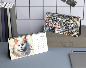 Könnte beinhalten: Ein Schreibtischkalender mit einem farbenfrohen Design, das eine Collage von Katzen zeigt. Der Kalender ist auf August 2023 geöffnet und zeigt die Zahlen 1 bis 31. Der Kalender steht auf einem Schreibtisch mit einem Laptop und einem Stapel Bücher.