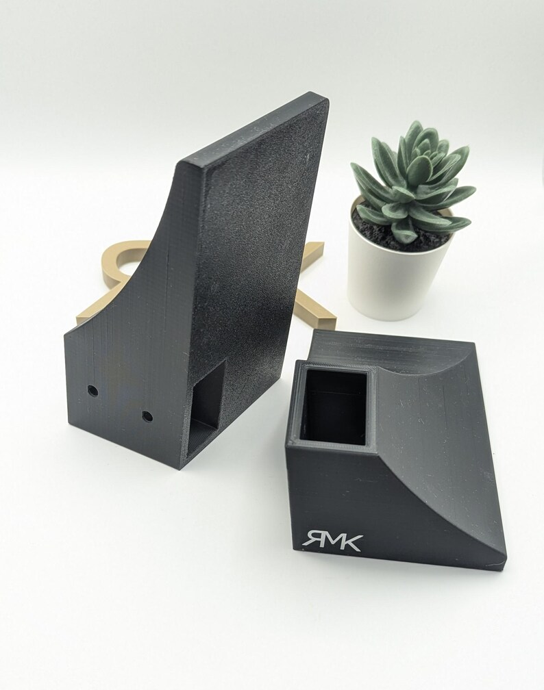 Puede incluir: Dos rampas de skate de pl&aacute;stico negro, una es un cuarto de tubo y la otra es un borde. El borde tiene la palabra "RMK" impresa.