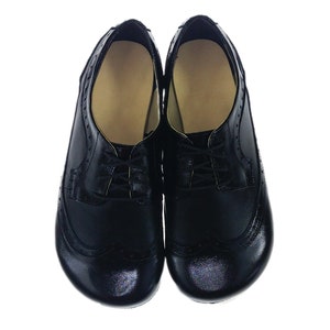 May include: A pair of black leather shoes with brogue detailing and lace-up closures.