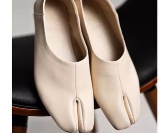 Tabi-Ballerinas: Weiße Ballerinas mit geteilter Zehenpartie, schwarze Tabi-Ballerinas