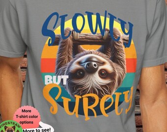 Könnte beinhalten: Ein graues T-Shirt mit einer Grafik im Vintage-Stil eines Faultiers, das kopfüber hängt. Die Grafik lautet "Slowly But Surely".
