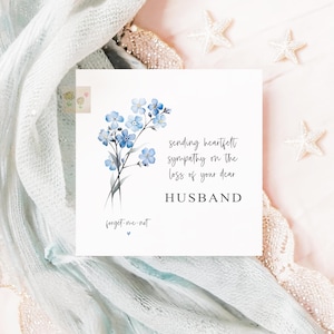 May include: A square sympathy card featuring a watercolor illustration of blue forget-me-not flowers. The card's text reads "Sending heartfelt sympathy on the loss of your dear husband" and "forget-me-not".
