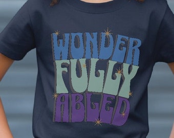 May include: A navy blue t-shirt with the words "Wonder Fully Able" in colorful, stylized lettering. The letters are outlined in gold glitter.