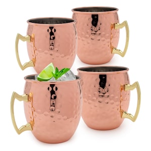 May include: Four copper Moscow Mule mugs with a hammered finish and gold-colored handles. One mug is filled with ice, a lime wedge, and mint sprigs. The other three mugs are empty. The mugs are displayed on a white background.