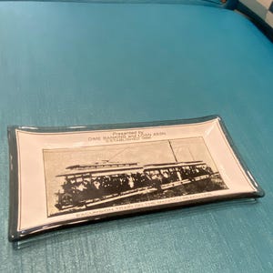 Bandeja de lembrancinhas do trem turístico da linha Manitou Beach, apresentada por um cofrinho de dez centavos.