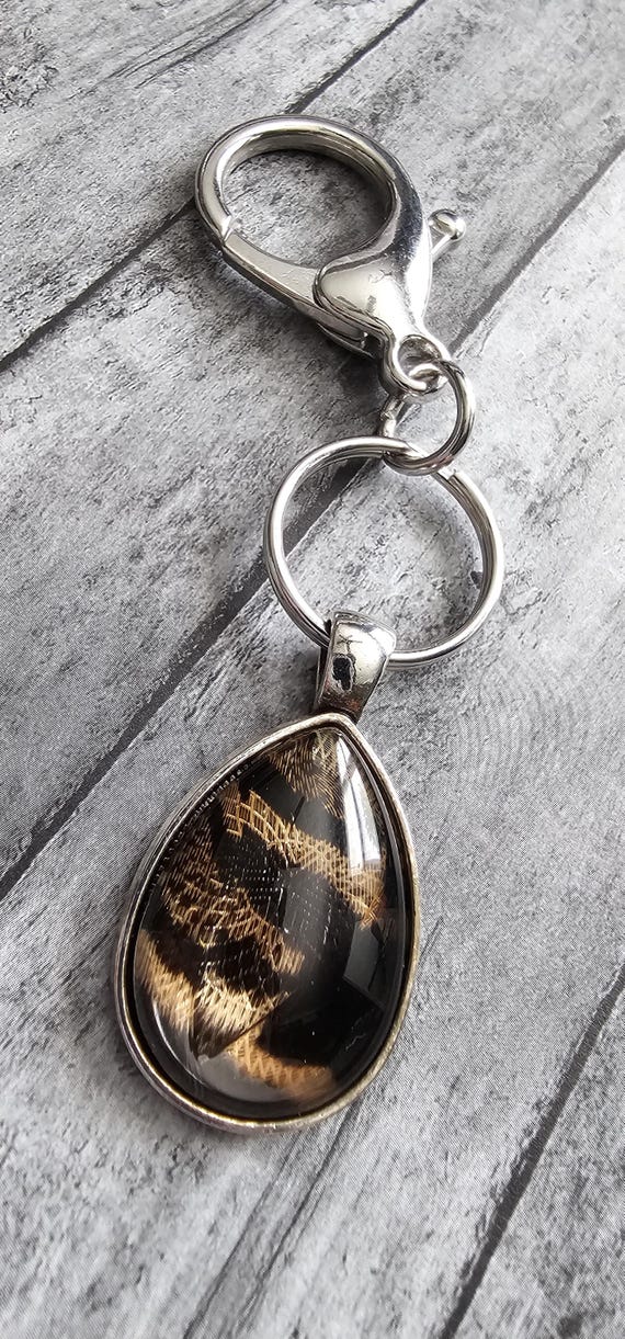 Natural bird feather resin sealed in a glass cabochon pendant keychain