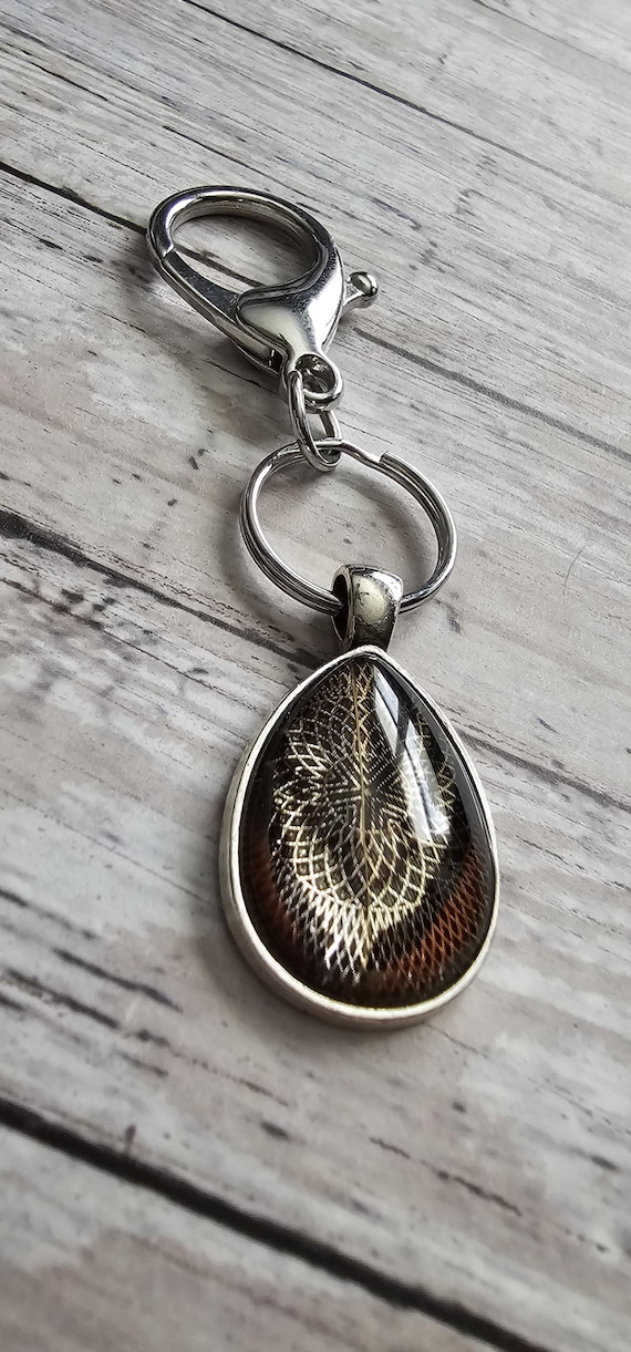 Natural bird feather resin sealed in a glass cabochon pendant keychain
