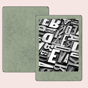 May include: A green e-reader with a black and white image of a jumbled collection of letters on the screen.