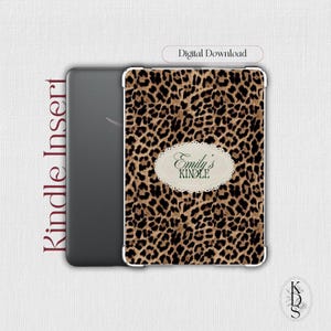 May include: A Kindle insert featuring a brown and black leopard print pattern. Centered on the front is an oval scalloped label with the text Emily's KINDLE. The text Kindle Insert and Digital Download are visible on the side and top.