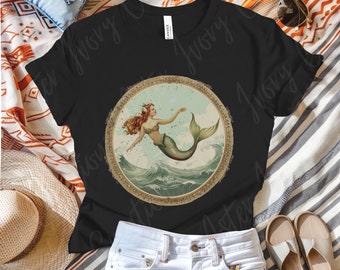 Puede incluir: Una camiseta negra con una ilustración de estilo vintage de una sirena con el pelo largo rojo y una cola verde. La sirena está rodeada de olas y enmarcada en un círculo dorado.