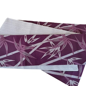 May include: A purple fabric sash with a white bamboo pattern. The sash is folded in thirds and has a light gray lining.