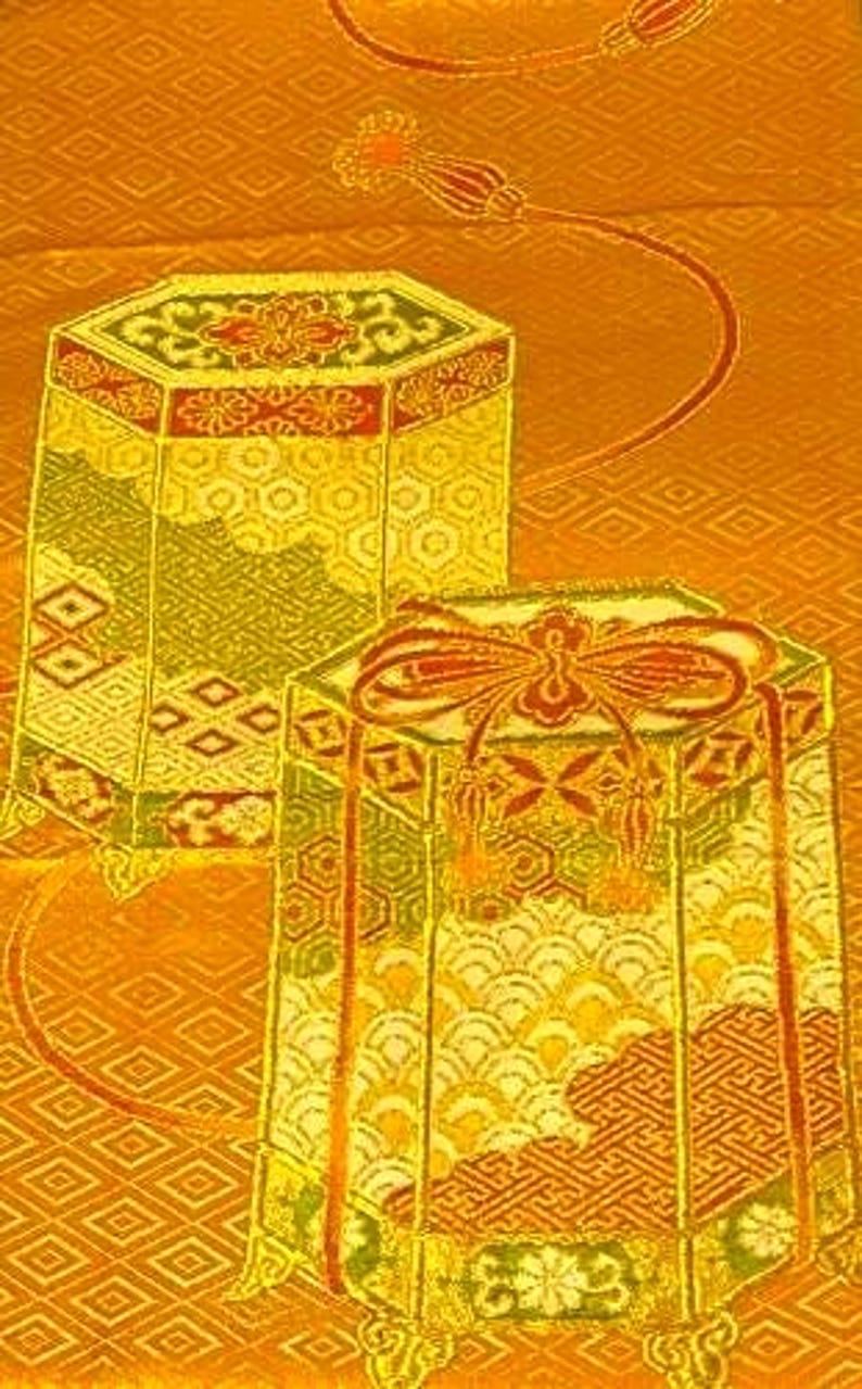 Op de afbeelding: Twee sierlijke, zeshoekige dozen met ingewikkelde patronen en gouden accenten. De dozen hebben rode en groene details en staan tegen een goudkleurige achtergrond met patronen. De dozen lijken decoratief te zijn of voor opslag.