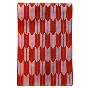 May include: A rectangular textile piece featuring a vibrant orange background with a repeating pattern of light pink arrow-like shapes arranged in vertical columns. The fabric displays a consistent woven texture throughout the entire surface area.