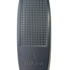 May include: A dark gray insole with a textured surface. The insole has a rounded top and a rectangular bottom with a smaller textured area. The letter "L" and Japanese text are printed on the insole.