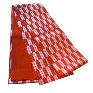 May include: A folded textile featuring a repeating pattern of white arrow-like shapes on a vibrant orange background. The fabric displays a consistent geometric design across its surface, with one section showing a solid orange color and another section displaying the arrow motif.