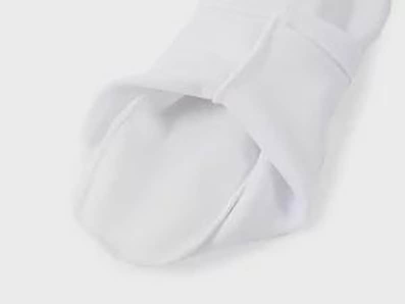 May include: Close-up of the white fabric lining of a white hoodie. The fabric is soft and smooth.