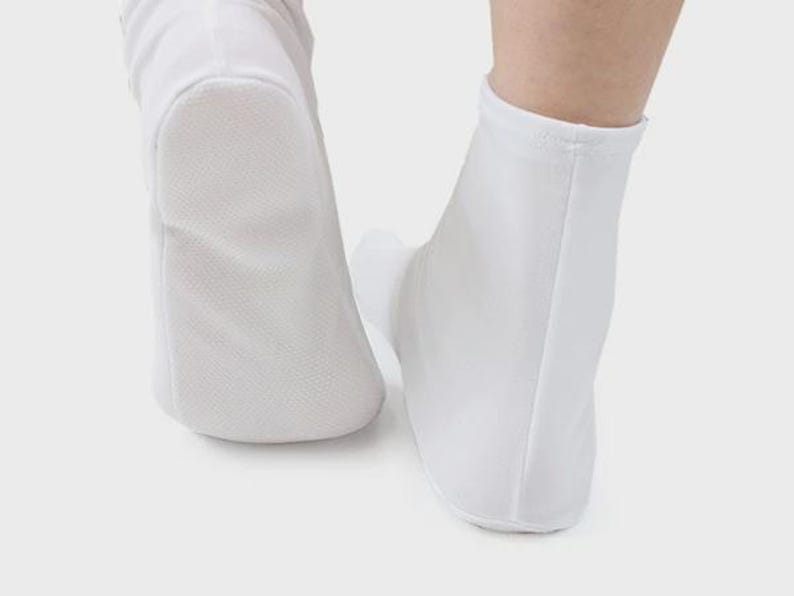 May include: A pair of white ankle-length socks with a smooth, textured surface. The socks are made of a soft, breathable material.