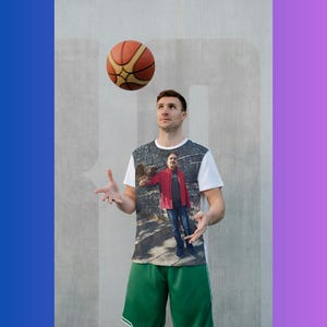 May include: A white t-shirt with a photo print of a person wearing a red jacket and blue jeans. The person is wearing green shorts and is juggling a basketball. The basketball is brown and orange.