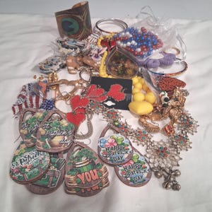 May include: A selection of jewellery and accessories, including beaded necklaces, earrings, bracelets, and decorative pendants. Features St. Patrick's Day themed tags, heart-shaped earrings, and a peacock feather cuff.