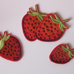 May include: Four embroidered iron-on patches of red strawberries with green leaves. The patches are ideal for adding a touch of whimsy to clothing, bags, or other fabric items.