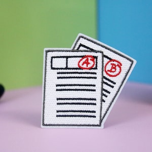 Puede incluir: Dos hojas de papel blancas con líneas negras y círculos rojos con las letras "A" y "B" dentro. Las hojas están apiladas una encima de la otra.