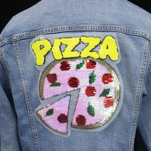 May include: A blue denim jacket with a sequined pizza patch that says "PIZZA" in yellow letters.
