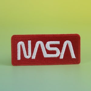 May include: A red embroidered patch with the white NASA logo.