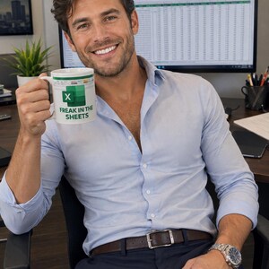 May include: White ceramic mug with the text "Freak in the Sheets" in black and green. The mug features the Microsoft Excel logo. The mug is held by a person wearing a light blue button-down shirt and a watch.