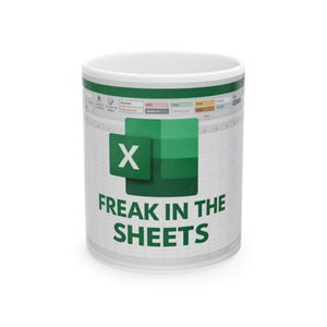 Op de afbeelding: Witte keramische mok met een groen en wit Excel spreadsheet ontwerp. De mok heeft het Excel logo en de tekst "FREAK IN THE SHEETS" in het groen.